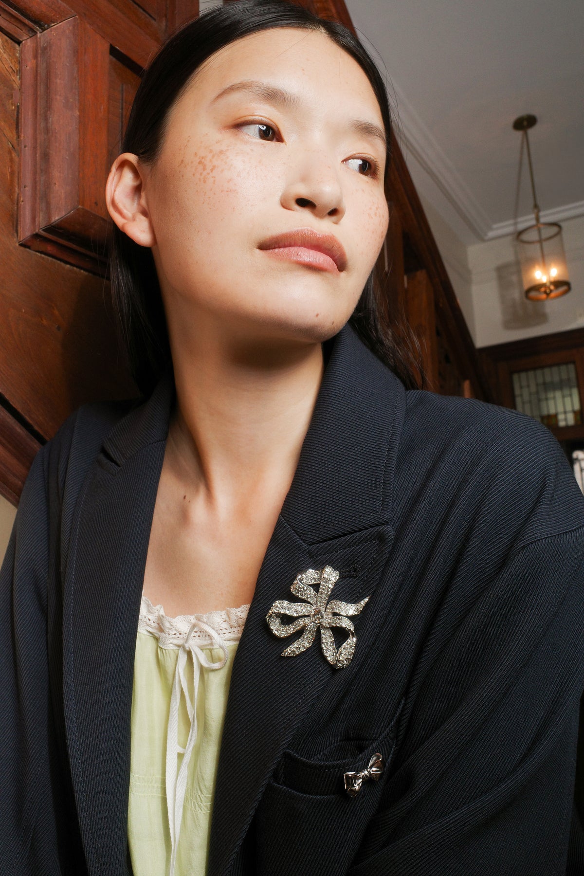 Seidler Vivienne Bow Brooch worn on a navy coat