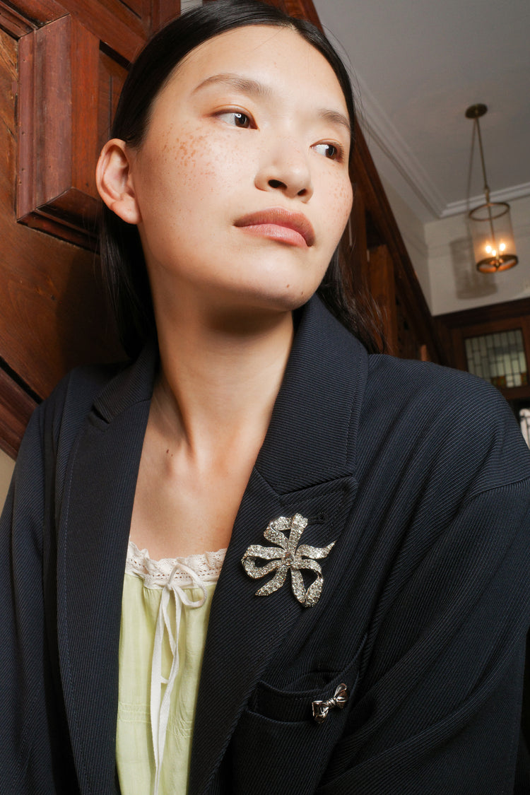 Seidler Vivienne Bow Brooch worn on a navy coat